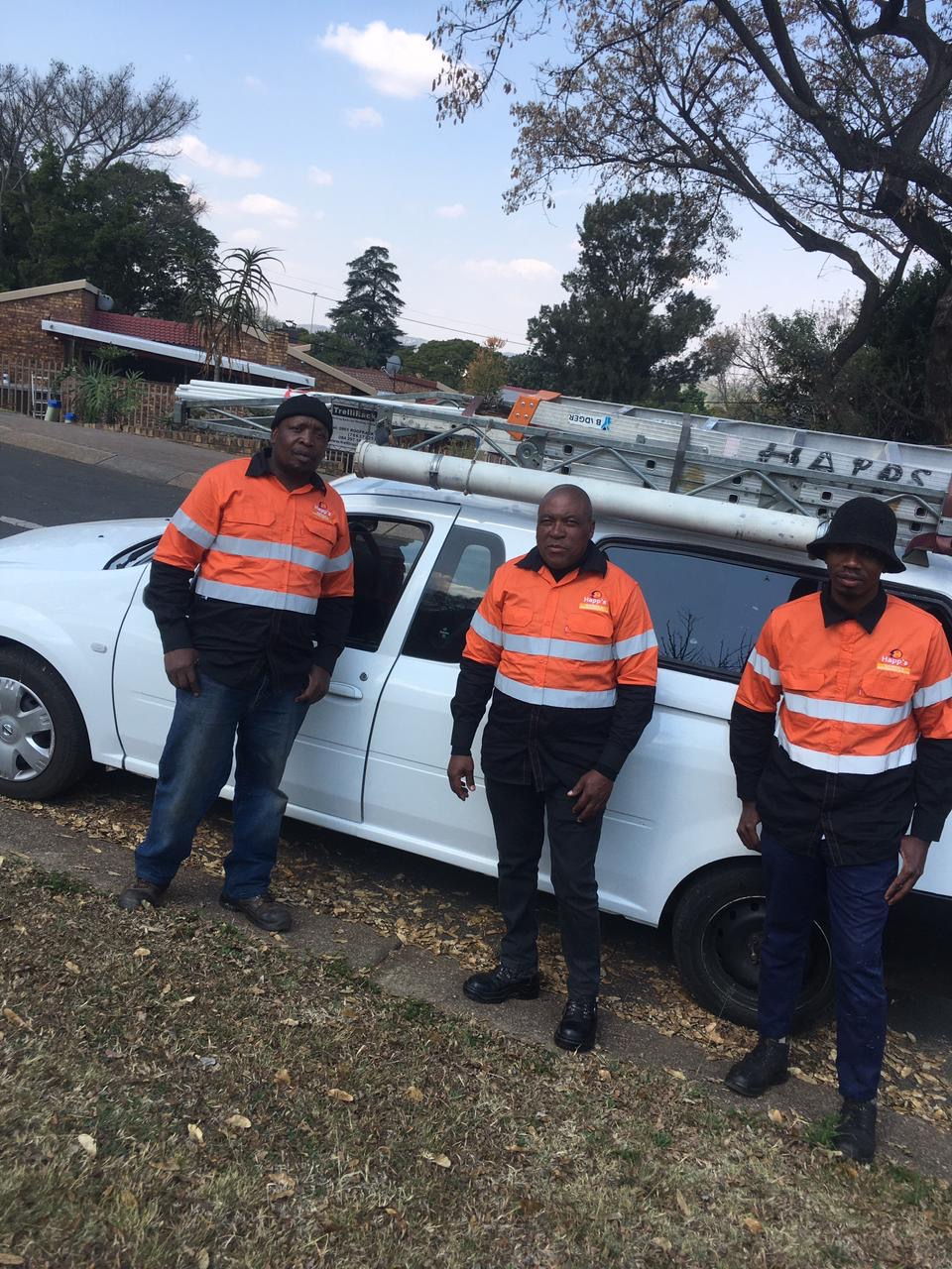 The Happ's Electrical team standing beside the branded company bakkie with ladders on the roof rack