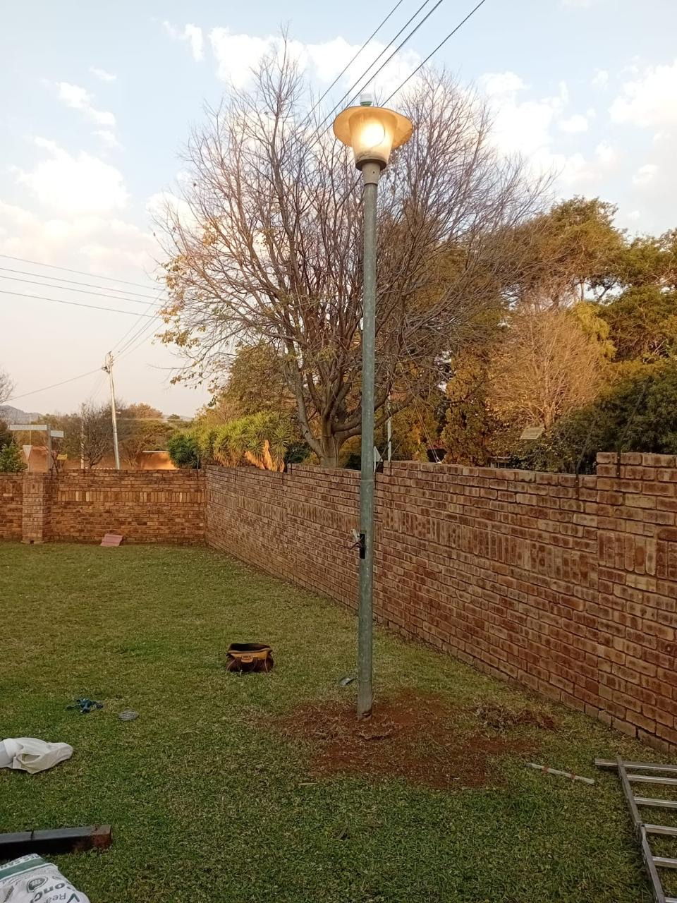 Newly installed garden lamp pole lighting up a Gauteng property boundary wall at dusk