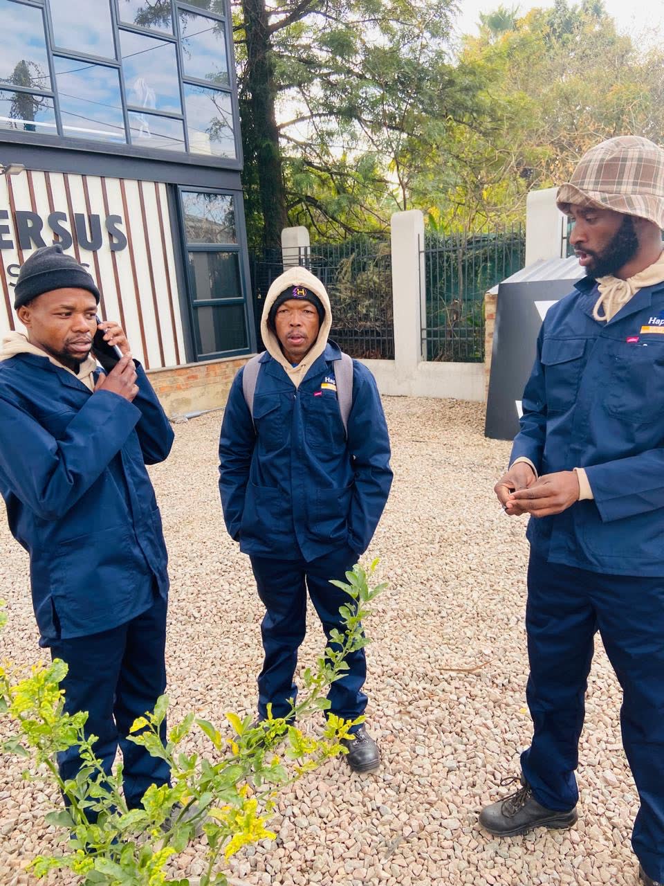 Happ's Electrical electricians in branded navy overalls planning work on a Gauteng site